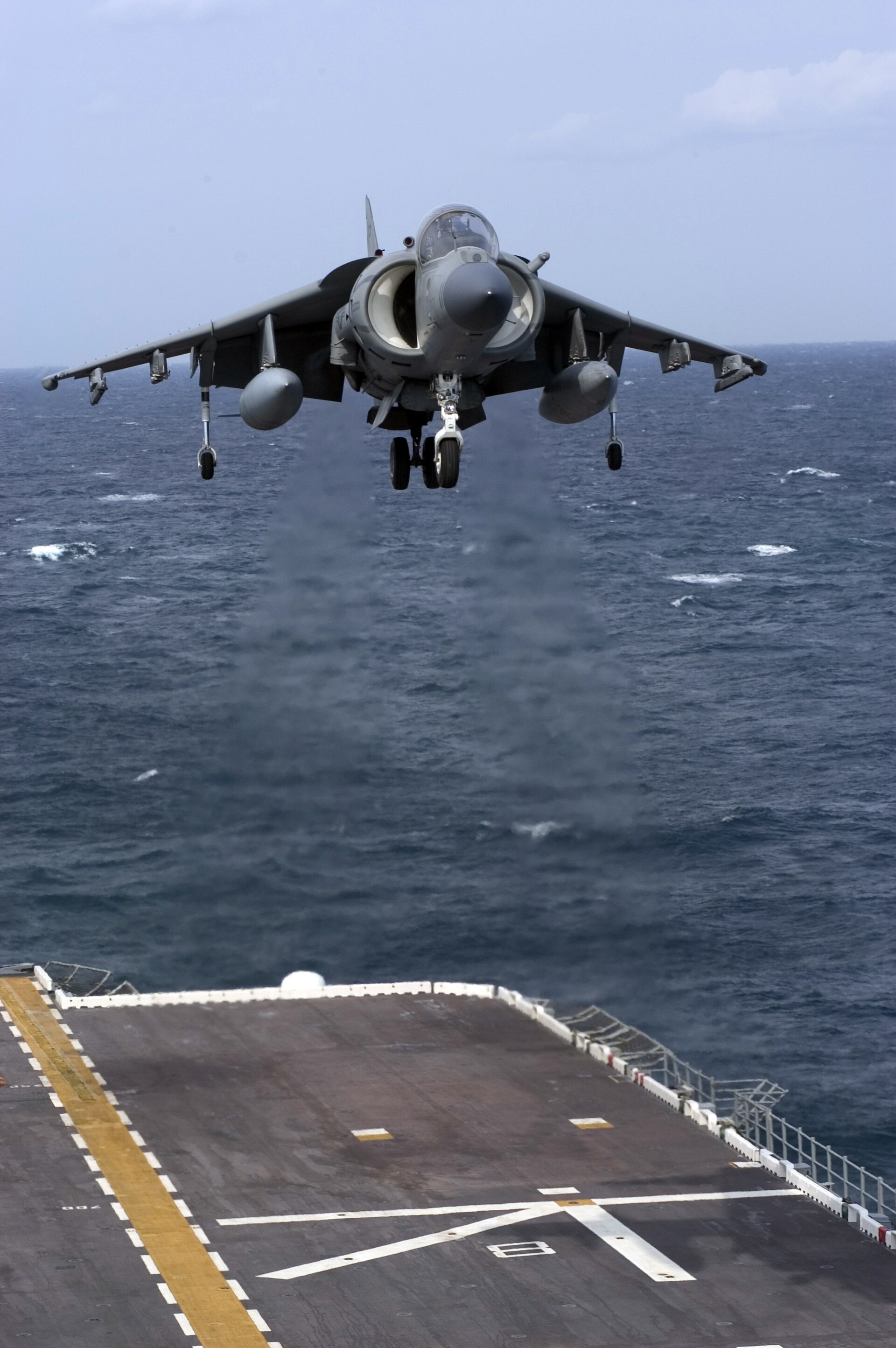 一架 AV-8B 鹞式攻击机，机身侧面朝向画面，机翼下方挂着外挂架